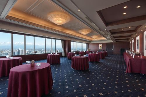 a row of tables in a room with windows at ANA Crowne Plaza Toyama by IHG in Toyama