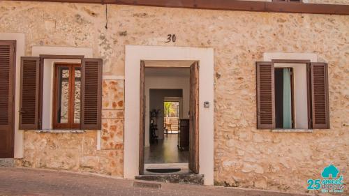 a building with two windows and a doorway at Son Ramis in Llubí