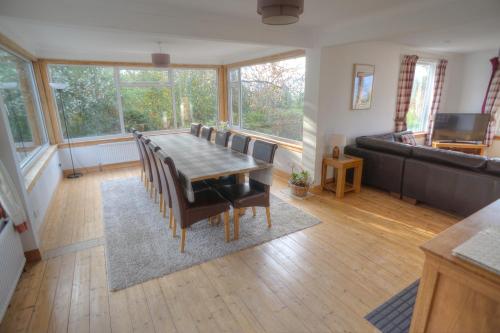 a dining room with a table and chairs and a couch at ArdFyne on Lochfyne in Strachur