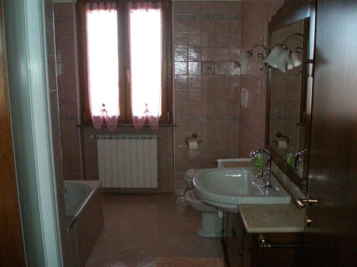 a bathroom with a sink and a toilet and a window at Bed and Breakfast il Faggio in Povegliano Veronese