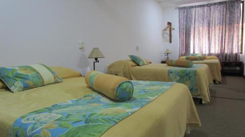 una habitación de hotel con 3 camas en una habitación en Sueño Tranquilo, en Quepos