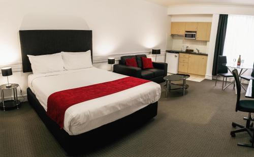 a hotel room with a large bed and a kitchen at Melbourne Kew Central Apartments Official in Melbourne