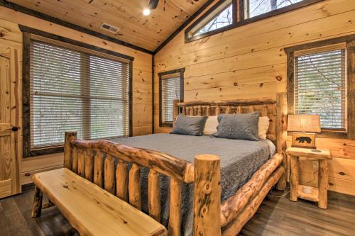 a bedroom with a bed in a log cabin at Luxe Cabin with Home Theater Less Than 2 Miles to Gatlinburg in Gatlinburg