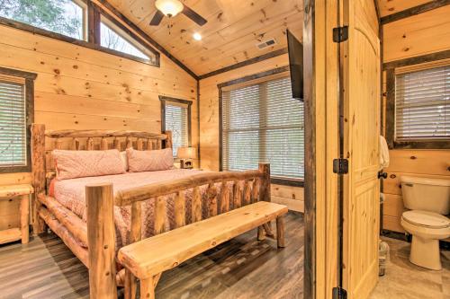 1 dormitorio con cama de madera y aseo en Luxe Cabin with Home Theater Less Than 2 Miles to Gatlinburg, en Gatlinburg