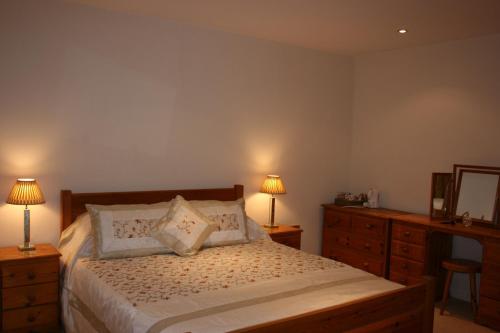 a bedroom with a bed with two lamps and a dresser at Torlands in Monmouth