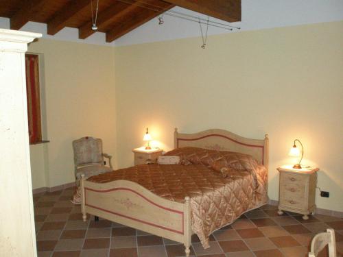 a bedroom with a bed with two night stands and two lamps at Bed and Breakfast il Faggio in Povegliano Veronese
