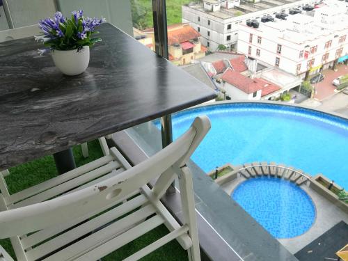 a white chair sitting on a table next to a swimming pool at Cheqma D'perdana Apartment Kota Bharu in Kota Bharu