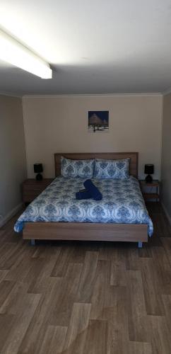 a bedroom with a bed with a wooden floor at Green Head Caravan Park in Green Head