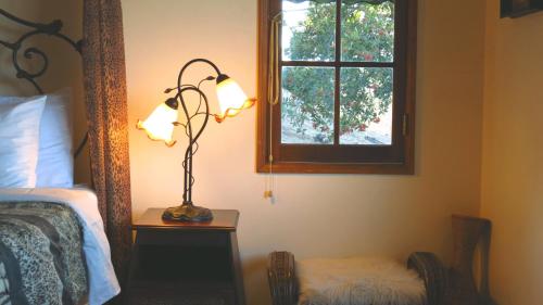 a bedroom with a lamp on a table next to a bed at Topanga Canyon Inn Bed and Breakfast in Topanga