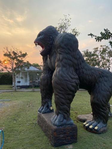 a statue of a black bear standing in the grass at Terrua Main Ten Villa Garden in Suan Phung