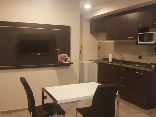 a kitchen with a table and chairs and a microwave at Complejo Edificio Rosario in San Juan