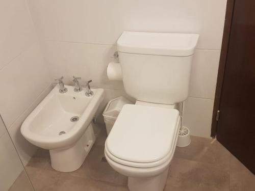 a bathroom with a white toilet and a sink at Complejo Edificio Rosario in San Juan