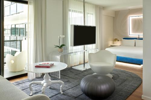 a white living room with a bed and a tv at Mondrian Los Angeles in Los Angeles