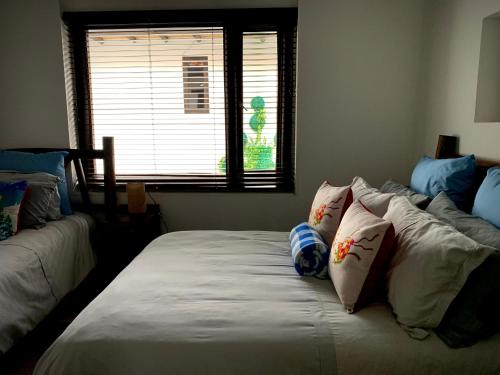 a bedroom with two beds with pillows and a window at La Casona Cucaita in Cucaita
