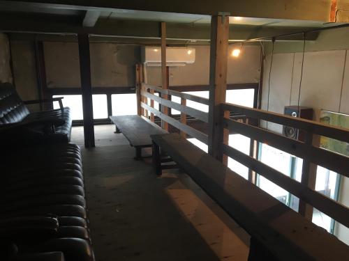 a room with benches in a train car at Bakushuku Den Guest House Brew in Matsuyama