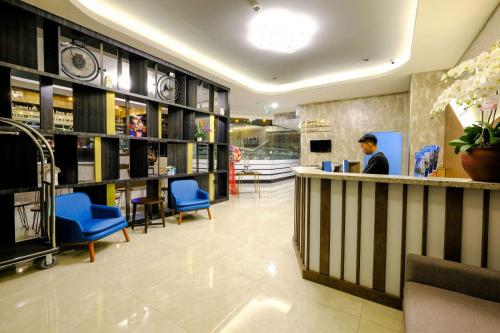 a man standing at a counter in a store at Desatu Hotel in Medan