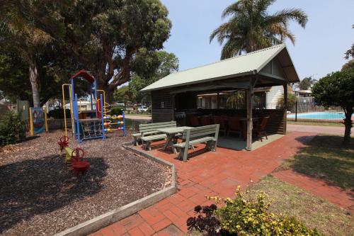 a park with a playground and a pavilion at Lazy Acre Log Cabins in Lakes Entrance