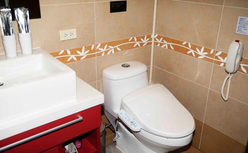 a bathroom with a white toilet and a sink at HATAGO+ THE ALLEY in Taipei