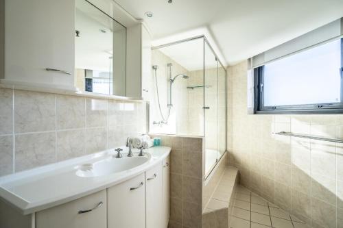 a bathroom with a sink and a shower and a mirror at Biarritz Apartments in Gold Coast
