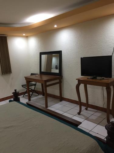 a room with a television and a table with a mirror at Casa Irma in Guatemala