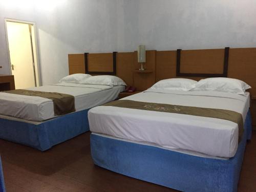 two beds sitting next to each other in a room at Mandalawangi Hotel Syariah in Tasikmalaya