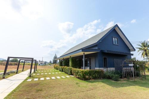 a blue house sitting on top of a yard at The Barn Hua Hin in Khao Tao