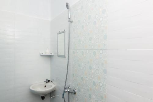 a white bathroom with a sink and a shower at RedDoorz Syariah near Tanjung Pinang City Center in Tanjung Pinang 