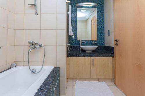 a bathroom with a bath tub and a sink at Luxury 2 Bed Room Apartment Palm Jumeirah Dubai in Dubai
