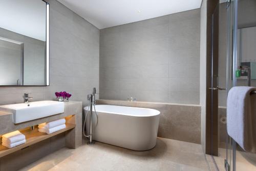 La salle de bains est pourvue d'une baignoire blanche et d'un lavabo. dans l'établissement Holiday Inn Guiyang City Center, an IHG Hotel, à Guiyang