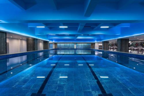 - une piscine avec éclairage bleu dans un bâtiment dans l'établissement Holiday Inn Guiyang City Center, an IHG Hotel, à Guiyang