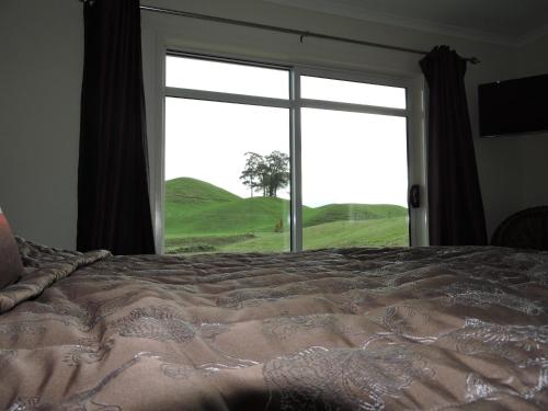 a bedroom with a bed and a window with a view at 5 Acres B&B in Tokoroa