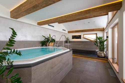 a large bathroom with a large tub with plants at Hotel Jenewein in Obergurgl