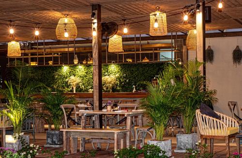 un restaurante con mesas, sillas y plantas en Lokal Phuket "Former K-Hotel" - SHA Extra Plus, en Patong Beach