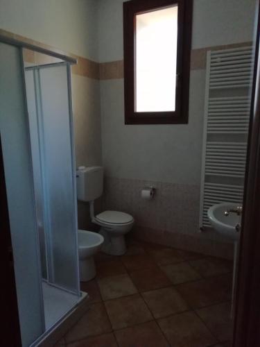 a bathroom with a toilet and a sink and a window at Agriturismo I Fondacci in Grizzana