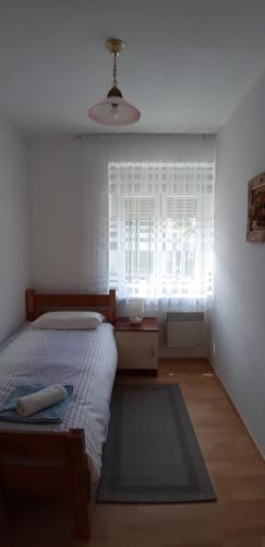 a bedroom with a bed and a window and a rug at Apartment Ivana in Gospić