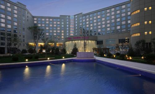 um hotel com piscina em frente a um edifício em Crowne Plaza Tianjin Binhai, an IHG Hotel em Tianjin