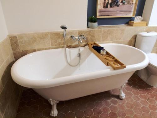 a white bath tub in a bathroom with a toilet at Cent Cinq - unique apartments in the heart of Apt in Apt