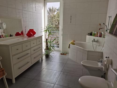 a bathroom with a sink and a tub and a toilet at House Susanne in Cologne