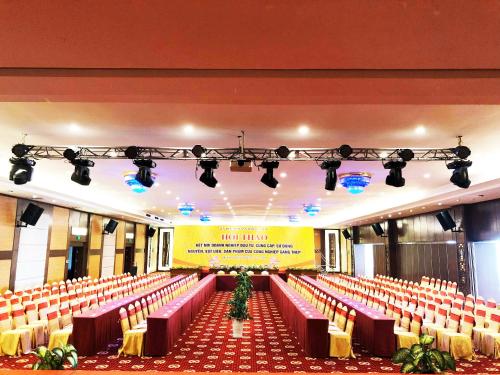 a large hall with red chairs and a stage at Muong Thanh Grand Ha Tinh Hotel in Kỳ Anh