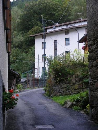 an empty street in front of a white building at La casa alta in Corteno Golgi