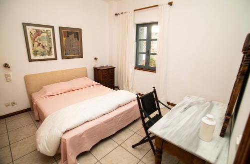 ein kleines Schlafzimmer mit einem Bett und einem Tisch in der Unterkunft Villa Popillon 1 in Kalymnos