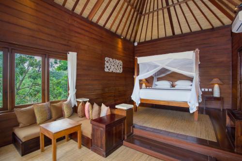 - une chambre avec un lit et un canapé dans l'établissement Tegal Sari Accommodation Ubud, à Ubud