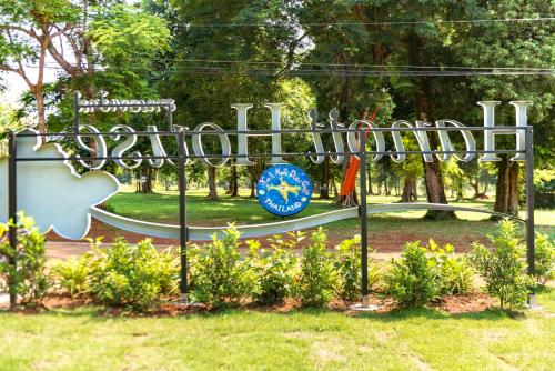 a metal sign in the grass with a playground at Hanoii House in Ko Mak
