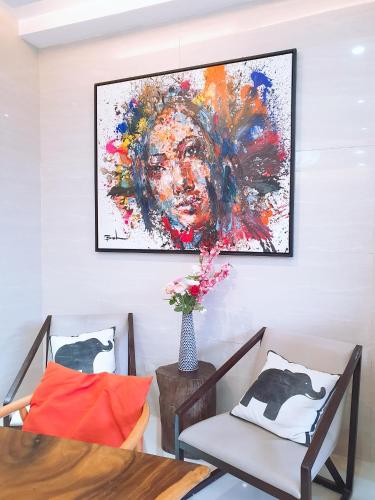 a dining room with two chairs and a painting on the wall at BLUE OCEAN BOUTIQUE HOTEL - Boracay Island in Boracay