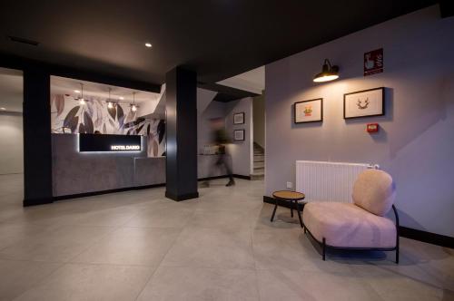 a room with a chair and a tv on a wall at U-Hotel Darío Lugo in Lugo