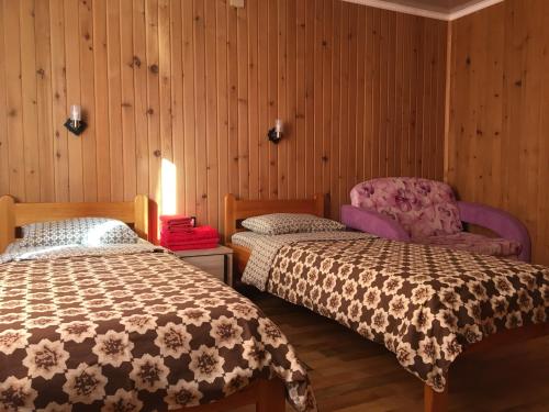 シェレゲシュにあるГостевой дом SNeGのベッド2台 木製の壁の部屋