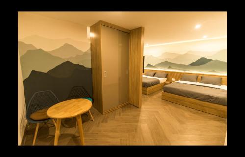 a bedroom with two beds and a table and a table at AHA Thang Bom Apartment Da Nang in Danang