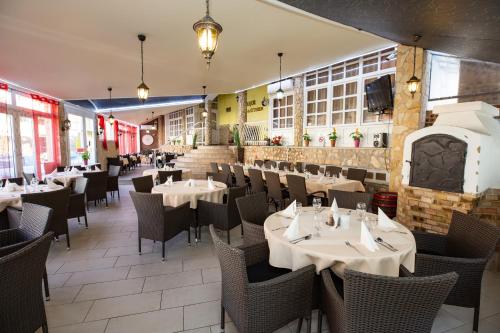 a restaurant with tables and chairs in a room at Major Panzió és Étterem in Hajdúszoboszló