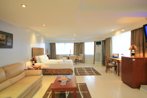 Habitación de hotel con cama y sala de estar. en Wild Orchid Beach Resort en Olongapo
