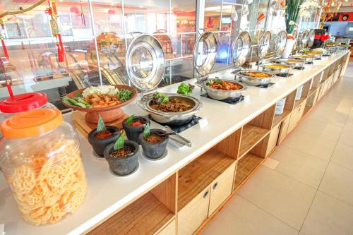 a buffet line with many bowls of food at HARRIS Hotel Pontianak in Pontianak